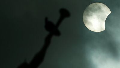 The Anjo Moroni statue atop the church of the Mormons is photographed while the solar eclipse is seen in Manaus, Brazil. Bruno Kelly / Reuters