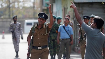 Police clear the area while bomb squad officers inspect the site of an exploded van. Reuters