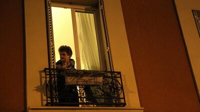 A person looks through a window after gunshots were heard as police raided during an operation in the city centre of Saint-Denis, near Paris. Yoan Valat / EPA