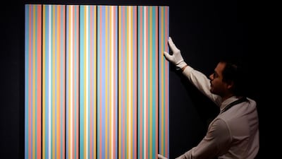 An employee poses with 'Songbird' by Bridget Riley ahead of the George Michael online auction at Christie's. Reuters