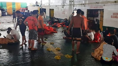 Coastguard personnel attend to rescued ferry passengers from the Lite Ferry after it caught fire early on August 28 off Dapitan, in southern island of Mindanao. AFP