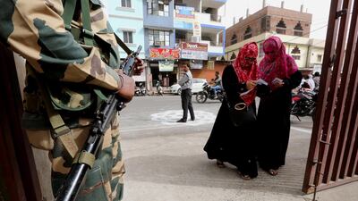 An Indian paramilitary officer stands guard as voters arrive to cast votes at a polling station during the sixth phase of the Indian parliamentary election in Bhopal, India. EPA