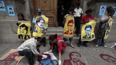 Activists spray paint images of people who went missing during the internal armed conflict at the entrance of the Congress building during a protest in Guatemala City. Jorge Dan Lopez / Reuters