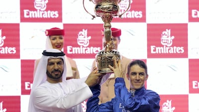 Trainer Saeed bin Suroor, left, and jockey Christophe Soumillon lift the Dubai World Cup after Thunder Snow's victory. Chris Whiteoak / The National