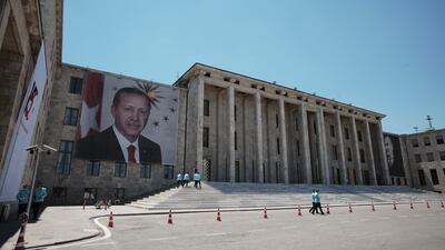 Giant portraits of President Recep Tayyip Erdogan, left, and Turkey's founder Mustafa Kemal Ataturk, right, hang outside the parliament building in Ankara. AP