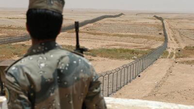 A Saudi border guard stands next to a fence on Saudi Arabia's northern border with Iraq on July 14, 2014. Faisal Al Nasser / Reuters