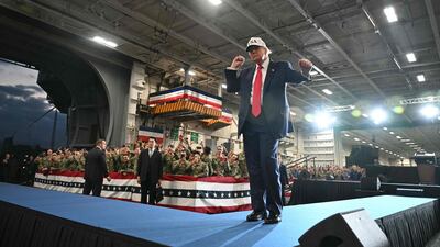 Mr Trump does a dance as he leaves after delivering a speech to US Navy personnel on board the USS George Washington. AFP