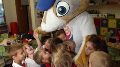 Children play with a man-sized Arabian dhabi (gazelle), the mascot of the Fifa Club World Cup tournament, after it was unveiled by the organisers.