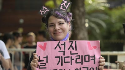 A fan holds up a sign in Korean for Jin ahead of the Coldplay concert.