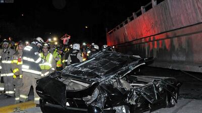 Rescue workers stand by a crushed car after the collapse of a bridge in an earthquake in Guayaquil, Ecuador. Marcos Pin Mendez / AFP Photo