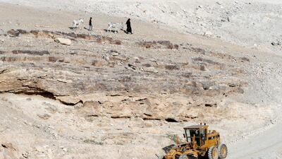 Bedouin children walk past an Israeli army excavator in the Palestinian Bedouin village of Khan al-Ahmar, east of Jerusalem in the occupied West Bank on October 16, 2018. AFP