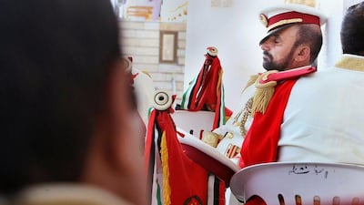 A member of the military band takes a nap while waiting for the National Day festivities to start at Heritage Village on Wednesday.