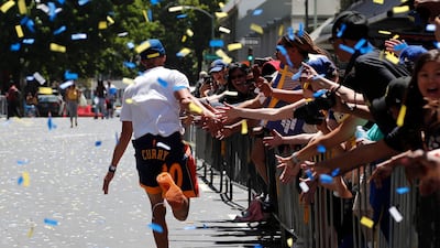 Golden State Warriors guard Stephen Curry runs down a street to greet fans along the route. John G. Mabanglo / EPA