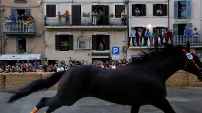 People watch the Palio di San Bartolomeo event from balconies.