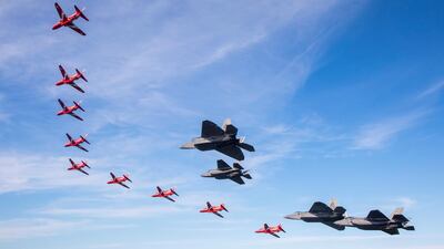US Air Force F-35s and F-22 Raptors in formation with the Red Arrows.