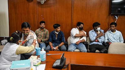 A health worker inoculates a man with a booster dose.