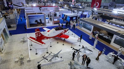 A Turkish Aerospace Industries' propeller-driven Hürkus (Free Bird) trainer and ground attack aircraft on display with scale models of other planes at the Doha International Maritime Defence Exhibition in the Qatari capital.