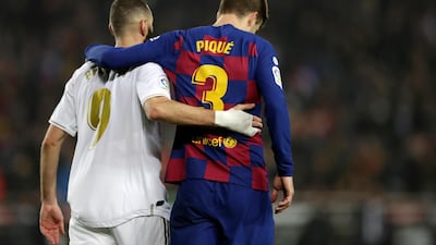 Real Madrid's Karim Benzema, left, and Barcelona's Gerard Pique walk together during the La Liga match between Barcelona and Real Madrid. AP