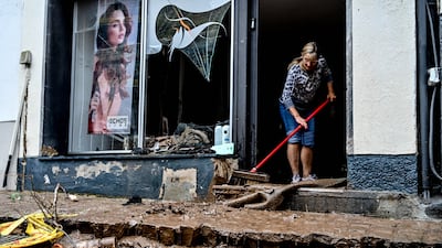 The calm after the storm: A woman sweeps floodwater from her shop doorway in Bad Muenstereifel, Germany.
