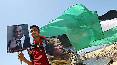 A Palestinian youth holds posters of the Libyan leader, Muammar Qadafi, and the leader's son Seif al Islam during a rally in support of the Libyan aid ship threatening to run the Israeli blockade of Gaza.