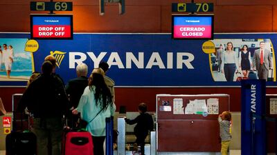 Passengers stand in front of closed check-in counters of Ryanair at Barcelona's El Prat airport in Spain. AFP