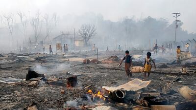 Rohingya refugee boys salvage a gas cylinder after a major fire in Balukhali camp at Ukhiya in Cox's Bazar district, Bangladesh, Sunday, March 5, 2023. A massive fire raced through a crammed camp of Rohingya refugees in southern Bangladesh on Sunday, leaving thousands homeless, a fire official and the United Nations said. (AP Photo / Mahmud Hossain Opu)