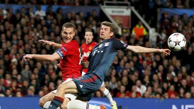 Manchester United defender Nemanja Vidic challenges Bayern Munich player Thomas Mueller, right, during a Champions League quarter-final first leg 1-1 draw on Tuesday. Stefan Wermuth / Reuters / April 1, 2014
