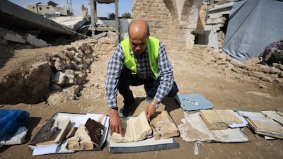 A member of Gaza's Department of Archaeological Manuscripts collects works to salvage books and manuscripts from the Great Omari Mosque Library that were damaged in the war. Anadolu via Getty Images