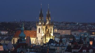 The Gothic Tyn Church in Old Town Square is illuminated at night. Old Town, one of Prague's most charming quarters, is full of historic buildings in various architectural styles.