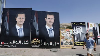 A man walks past a poster of President Bashar Al Assad, a candidate for the Presidential election, in the Syrian capital Damascus. AFP