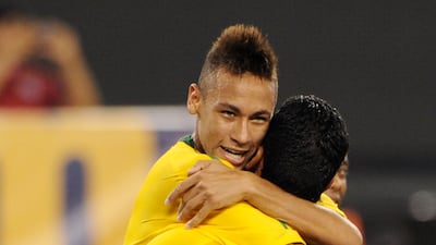 Neymar, left, is hugged by teammate Andre Santos after scoring a header on his international debut for the Selecao. AFP