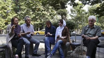 Iranians enjoy ice-cream on a sidewalk in northern Tehran. Vahid Salemi / AP