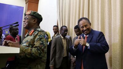 Sudan's new Prime Minister Abdalla Hamdok gives thumbs up as the presidential palace spokesman presents him to the media for a press conference following his swearing in at the presidential palace in Khartoum, Sudan. EPA