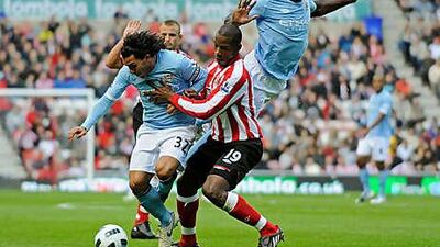 Titus Bramble of Sunderland challenges Micah Richards, top, and Carlos Tevez of Manchester City during the match, which the home side won thanks to a last-minute penalty from Darren Bent.