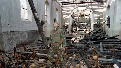 A Bosnian soldier surveys a destroyed church in Stup, in March 1993. AFP