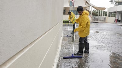 Maintenaince staff sweep water away after overnight rainfall in the Greens. Antonie Robertson / The National