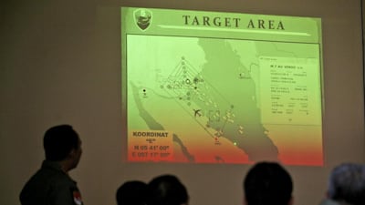 Indonesian air force officers examine a map showing their operation area over the Strait of Malacca in the search for the missing Malaysia Airlines plane, at Suwondo air base in Medan, North Sumatra, on March 13, 2014. Binsar Bakkara / AP Photo