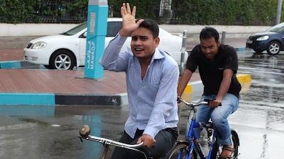 Two men have a refreshing cycle in the rain in Abu Dhabi. Brian Kerrigan / The National