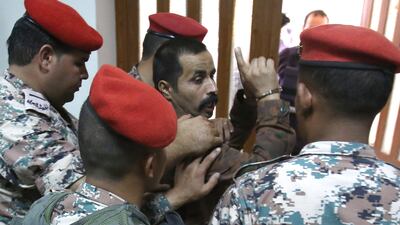 Maarik Al Tawaiha is led out of a military court in Amman on July 17, 2017 after being sentenced to life for the killing of three American military trainers outside an army base in southern Jordan last year. Khalil Mazraawi / AFP