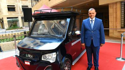 Lebanese engineer Hisham Houssami poses for a photo next to his locally-made car named 'Lira' during a ceremony to unveil the vehicle outside the Ministry of Economy in downtown Beirut, Lebanon, 08 July 2023. According to Houssami, the car called 'Lira' is a Lebanese-made vehicle that is powered by fast-charge battery and solar panels and can travel about 150 miles. Due to the economic crisis which has led to an energy crisis, Lebanese people are looking more into solar energy to run home appliances and small businesses. EPA / WAEL HAMZEH