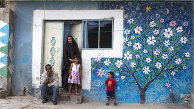 A bright mural of a flowering tree adorns the one room dwelling of Palestinian refugee family Kamal Mousaid Tawfiq, 53, and his wife, Tahrir, 27 and their young children in the Balata refugee camp on the outskirts of the Palestinian city of Nablus on June 7. Heidi Levine for The National.