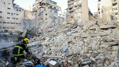 A firefighter looks at debris at the site of the Israeli air strike. AFP