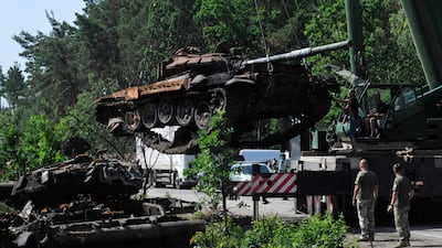 Ukrainian servicemen collect destroyed Russian tanks outside the village of Dmytrivka. AFP