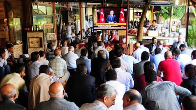 Kurdish people listen to Turkish prime minister Recep Tayyip Erdogan announcing reforms to their rights on TV, in Diyarbakir. Mehmet Engin / AFP