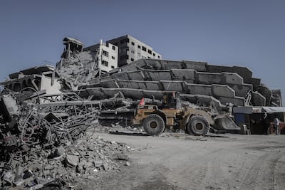 A bulldozer clears rubble near destroyed buildings in Gaza city. Bloomberg