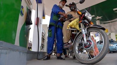 A worker fills the tank of a customer's motorcycle at a petrol station in Peshawar, Pakistan. Prices for distillates – diesel and jet fuel – have reached alarming heights in some markets. EPA