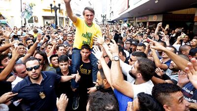 Presidential candidate Jair Bolsonaro is taken on the shoulders of a supporter moments before being stabbed during a campaign rally in Juiz de Fora, Brazil. Agencia O Globo via AP