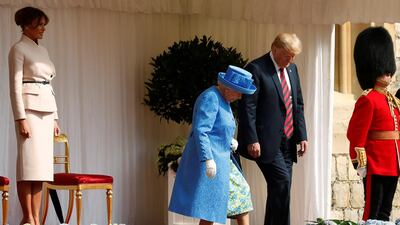 The First Lady Melania Trump waits as U.S. President Donald Trump and Britain's Queen Elizabeth walk across the courtyard to inspect the Coldstream Guards during a visit to Windsor Castle in Windsor, Britain, July 13, 2018. Reuters