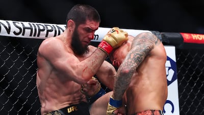 Dustin Poirier and Islam Makhachev exchange strikes in their lightweight title bout during UFC 302. AFP