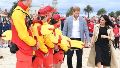 Harry and Meghan meet life guards on the beach. EPA